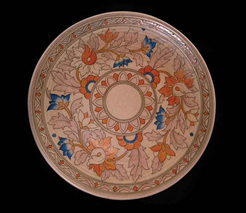 Charlotte Rhead charger Intricate art deco floral design in blue, orange and pale pink on buff background.